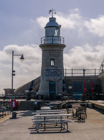 Photo for Folkestone, Kent, England - May 08, 2022: Lighthouse and benches of the restaurants on Folkestone Harbour Arm - Royalty Free Image
