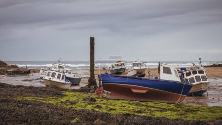 Photo for Bude, Cornwall, England, UK - June 07, 2022: Boats at low tide on the beach at Sir Thomas's Pit - Royalty Free Image