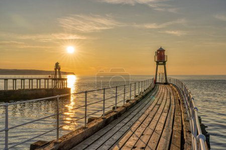 Sunset at the West and East Pier in Whitby, North Yorkshire, England, UK