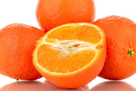 Foto de One half and three whole sweet organic tangerines, macro, isolated on white background. - Imagen libre de derechos
