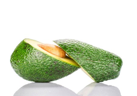 Photo for Two halves with a bone, cut across, lying side by side, a mature diet green avocado, on a white background. - Royalty Free Image
