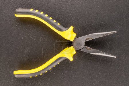 Photo for Pliers combined on slate stone, macro, top view. - Royalty Free Image
