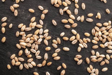 Photo for Organic pearl barley on slate stone, close-up, top view. - Royalty Free Image