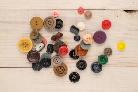 Photo for Many buttons on a wooden table, macro, top view. - Royalty Free Image