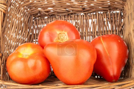 Photo for Several juicy red tomatoes in a basket, macro. - Royalty Free Image