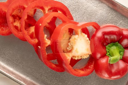 Foto de Pimienta roja dulce cortada en rodajas en una bandeja de metal, macro, vista superior. - Imagen libre de derechos