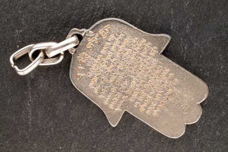 Photo for One metal keyring, Jewish "Hand of Miriam" on slate stone, close-up, top view. - Royalty Free Image