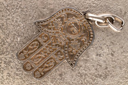 Photo for One metal keyring, Jewish "Hand of Miriam" on metal, close-up, top view. - Royalty Free Image