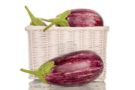 Photo for Three organic ripe eggplants in a basket, macro, isolated on white background. - Royalty Free Image