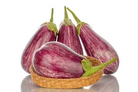 Photo for Several organic ripe eggplants with straw plate, macro, isolated on white background. - Royalty Free Image