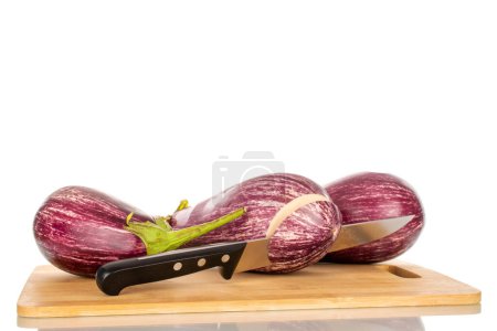 Photo for Three juicy eggplants with a knife on a bamboo kitchen board, macro, isolated on white background. - Royalty Free Image