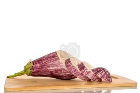 Photo for One juicy eggplant cut into pieces on a bamboo kitchen board, macro, isolated on white background. - Royalty Free Image