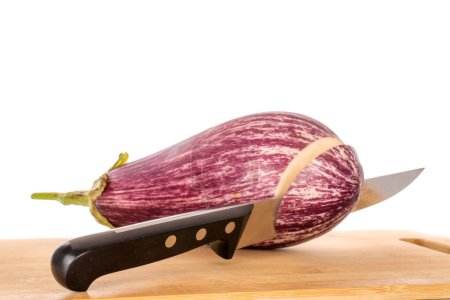 Photo for One juicy eggplant with a knife on a bamboo kitchen board, macro, isolated on white background. - Royalty Free Image