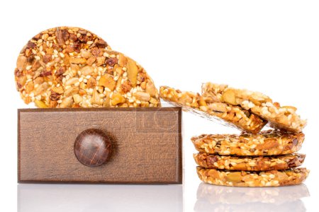 Several sweet Italian cookies with nuts in a wooden box, macro, isolated on white background.