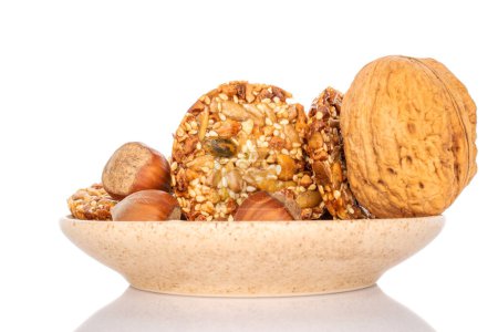 Several sweet Thaler cookies with nuts on a ceramic saucer, macro, isolated on white background.