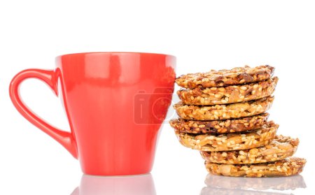 Plusieurs biscuits Thaler doux avec tasse en céramique rouge, macro, isolé sur fond blanc.