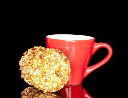 Photo for Two sweet Thaler cookies with red ceramic cup, macro, isolated on black background. - Royalty Free Image
