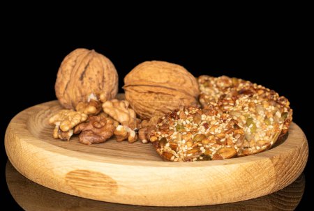 Several sweet Thaler cookies on a wooden plate, macro, isolated on black background.