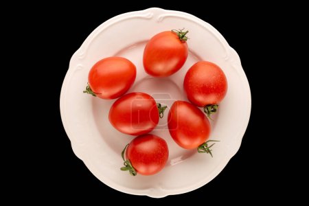 Foto de Varios tomates cóctel en un plato de cerámica blanca sobre un fondo negro, macro, vista superior. - Imagen libre de derechos