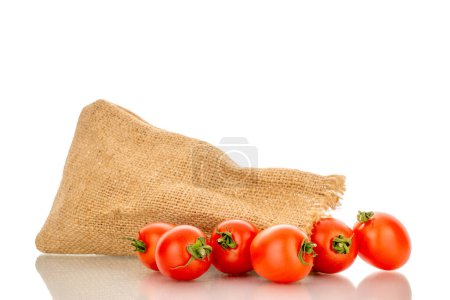 Foto de Varios tomates cherry maduros con una bolsa de yute, macro, aislados sobre fondo blanco. - Imagen libre de derechos