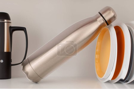 Photo for One vacuum-insulated metal bottle for water or coffee on the dish shelf. - Royalty Free Image