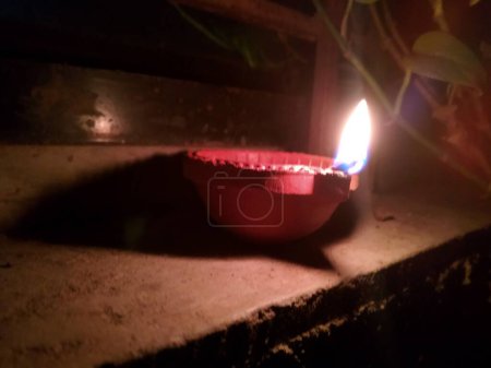 Téléchargez les photos : Lampe Diwali vue de face. Une lampe derrière un arbre Tulsi la nuit. vue rapprochée de la lampe Diwali. - en image libre de droit