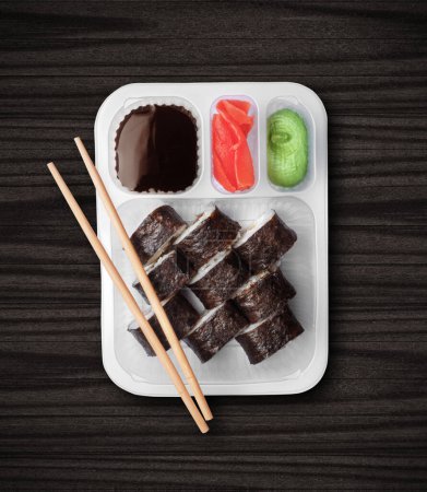 Foto de Sushi en caja de plástico primer plano sobre fondo de madera negro - Imagen libre de derechos