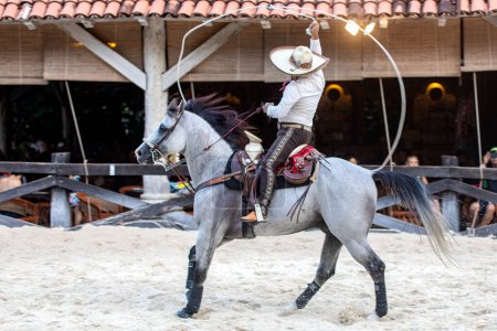 Foto de Ecuestres mexicanos con una magnífica exposición de movimientos de lasso en caballos aztecas de gran linaje, este es un espectáculo único en el Parque Xcaret en México. - Imagen libre de derechos