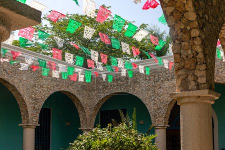 Foto de Amplio patio en una terraza fuera de una hacienda mexicana con banderas y decoraciones típicas de México, este es un edificio de arquitectura típica y construcción de este estado en lugares tropicales. - Imagen libre de derechos
