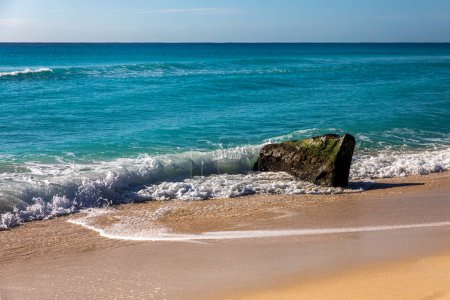 Photo d'un rocher sur la plage de dauphins dans la zone hôtelière de Cancun Mexique baigné par la mer des Caraïbes. C'est une plage paradisiaque tropicale de sable blanc et doré des Caraïbes très fréquentée par les touristes.
