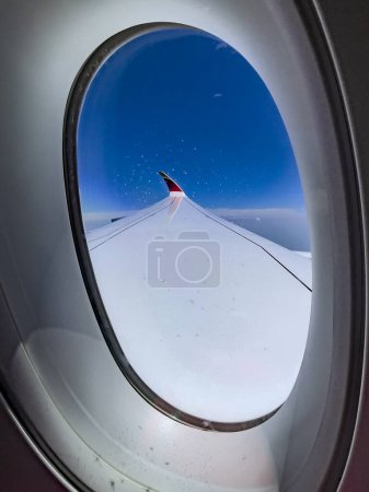 Foto de Madrid, España; 31 de mayo de 2023: Fotografía vertical del ala de un Airbus A350-900 de la aerolínea española Iberia, volando sobre las nubes y bajo un hermoso cielo azul en su camino a su destino. - Imagen libre de derechos