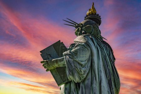 Téléchargez les photos : La dame de la Grosse Pomme, mieux connue sous le nom de Statue de la Liberté de New York au milieu de Manhattan sous un ciel rouge à l'aube. - en image libre de droit