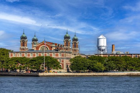 Foto de Nueva York, Estados Unidos; 1 de junio de 2023: Vista panorámica del Museo de Inmigración de Ellis Island bajo un hermoso cielo azul, típico de la Gran Manzana y Manhattan. - Imagen libre de derechos