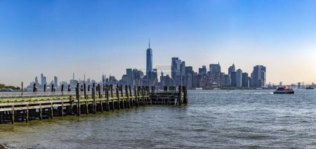 Foto de Nueva York, Estados Unidos; 1 de junio de 2023: Vista panorámica de Ellis Island y el horizonte de Nueva York bajo un hermoso cielo azul típico de la Gran Manzana y Manhattan - Imagen libre de derechos
