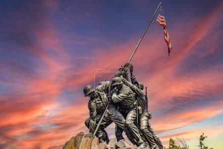 Das United States Marine Corps Iwo Jima War Memorial in Arlington, Washington DC (Virginia), bei Sonnenaufgang mit orangefarbenem Himmel.