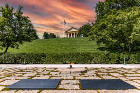 Zwei Sonnenuntergangs- oder Sonnenaufgangsgräber von John F. Kennedy und seiner Frau mit der ewigen Flamme am Denkmal auf dem Arlington National Military Cemetery (USA)).
