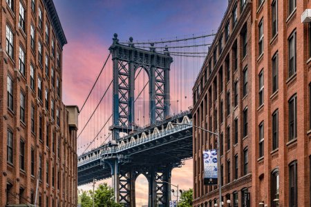 Photo for Wonderful sunrise or sunset in Dumbo the trendy Brooklyn neighborhood with picturesque views of the Manhattan skyline and its bridge, famous in New York City (USA). - Royalty Free Image