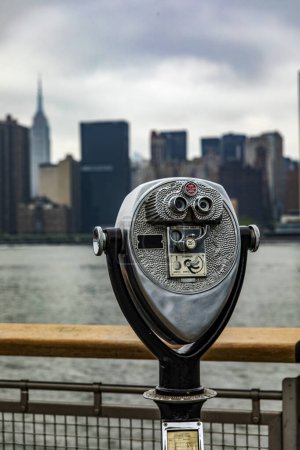 Foto de Los prismáticos en Long Island, que es una isla que se extiende a través de Nueva York (EE.UU.) y desde donde se puede ver perfectamente el horizonte de Manhattan con los rascacielos de la Gran Manzana. - Imagen libre de derechos