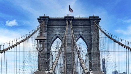 The famous and wonderful Brooklyn Bridge linking the boroughs of Manhattan and Brooklyn in New York City (USA), a day with blue sky and lots of clouds.