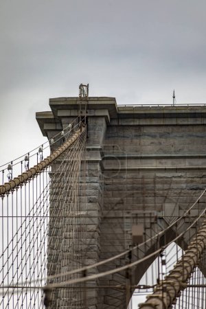 Photo for Upper left side of the Brooklyn Bridge linking the boroughs of Manhattan and Brooklyn in New York City (USA). It was the largest suspension bridge in the world, record span until 1889. - Royalty Free Image