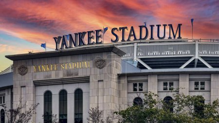 Téléchargez les photos : New York, États-Unis ; 3 janvier 2024 : Entrée et panneau au Yankee Stadium dans le Bronx, l'un des plus grands et des meilleurs parcs de ballon avec un beau ciel couchant. - en image libre de droit