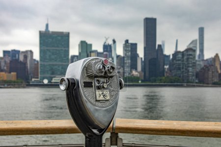 Foto de Mirando el horizonte de Manhattan con un binocular de Long Island que es una isla que se extiende a través de Nueva York (EE.UU.) desde donde se pueden ver los rascacielos de la Gran Manzana. - Imagen libre de derechos