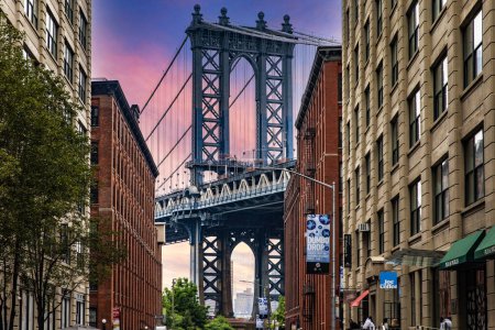Photo for New York, USA; June 3, 2023: The sunset from Dumbo the trendy Brooklyn neighborhood with picturesque views of the Manhattan skyline and bridge. - Royalty Free Image