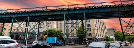 Foto de Nueva York, Estados Unidos; 3 de junio de 2023: Típicas vías de tren y tranvía del Bronx, un barrio de la Gran Manzana, bajo un cielo anaranjado al amanecer. - Imagen libre de derechos