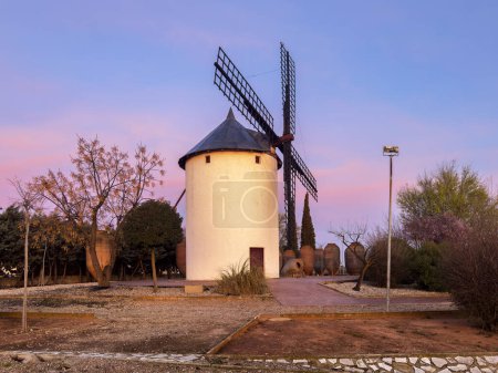 Eingang zur Stadt Villarrobledo mit einem wunderschönen orangen und orangefarbenen Sonnenaufgang, der die wunderschöne Windmühle des Landes von Don Quichote beleuchtet.