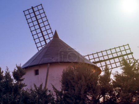 Sonnenaufgang und Beleuchtung der Flügel und des hinteren Bereichs einer Windmühle in der Stadt Villarrobledo in Kastilien-la Mancha, die sich in der Mitte Spaniens befindet.