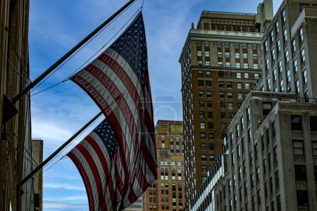Foto de Banderas estadounidenses ondeando en los rascacielos en el centro de Manhattan, en las calles de la Gran Manzana de Nueva York (EE.UU.). - Imagen libre de derechos