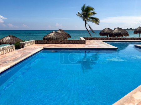 Swimmingpool mit kristallklarem türkisfarbenem Wasser im Hintergrund. Es ist ein idealer Ort, um Entspannung und Sommerurlaub zu genießen.