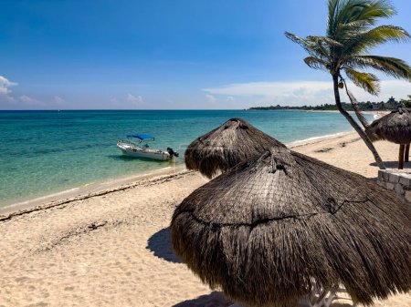 Boot auf dem weißen Sandstrand, mit dem türkisfarbenen und kristallklaren Wasser der Karibik, unter einer warmen und strahlenden Sonne und blauem Himmel, idealer Ort für einen Sommerurlaub.