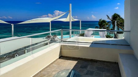 Terrasse et espace détente d'un hôtel de luxe Resort avec le paysage caribéen en arrière-plan typique d'une plage de sable blanc fin et d'eau turquoise cristalline idéale pour les vacances d'été.